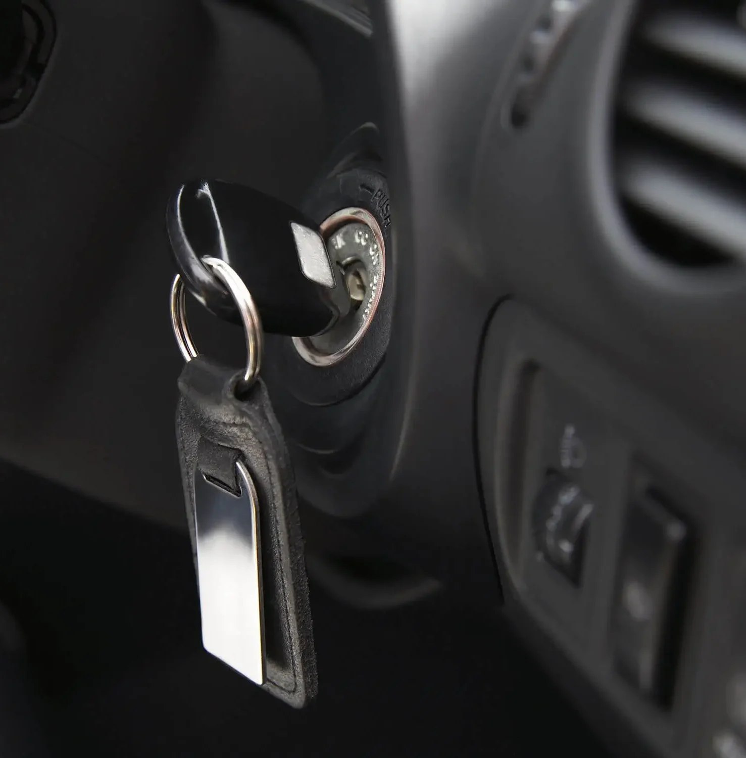 Close-up of a car key inserted into the ignition switch – key start vehicle