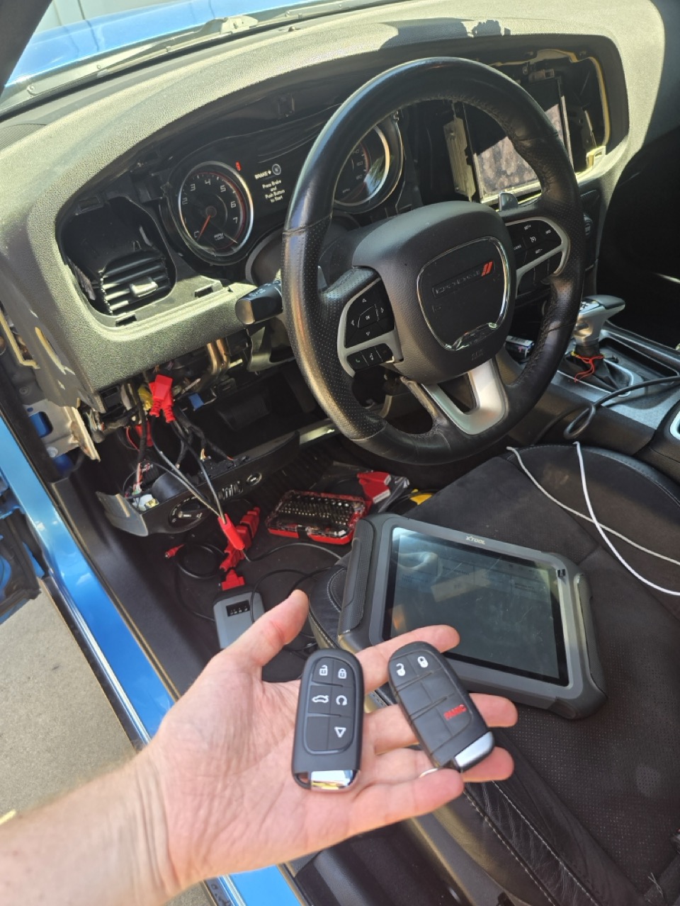 Dodge Charger car key replacement service with a locksmith technician programming a new key fob.